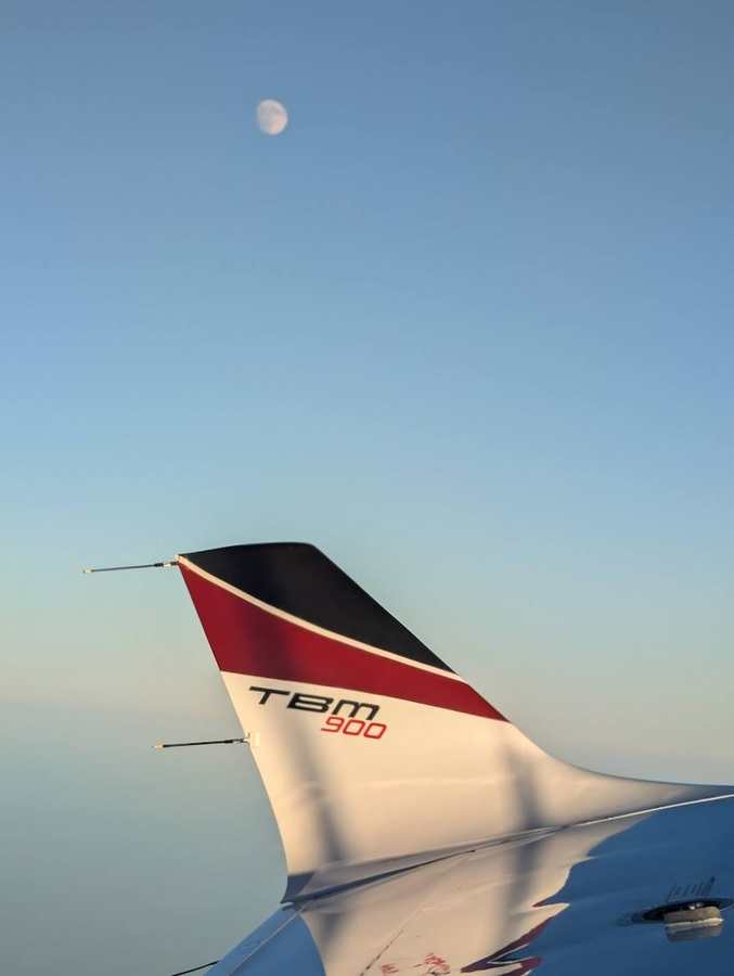 TBM 900 tail fin above the clouds with moon
